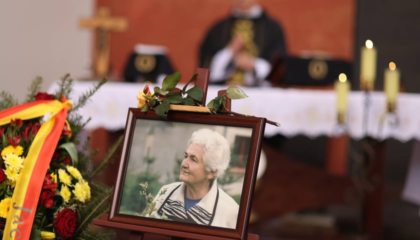 Ramka ze zdjęciem Wiesławy Różewicz, w tle: ksiądz za ołtarzem, 19 kwietnia 2024 roku