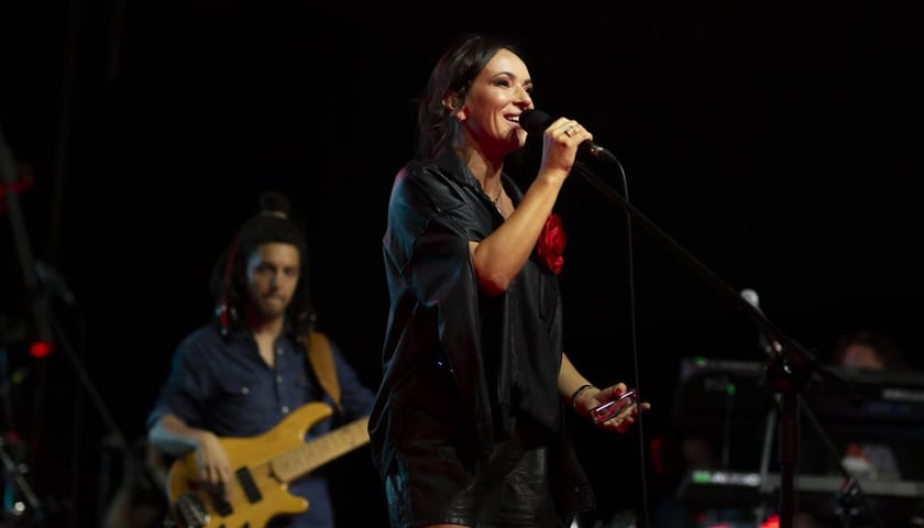 Kasia Kowalska podczas koncertu. Na zdjęciu kobieta z mikrofonem