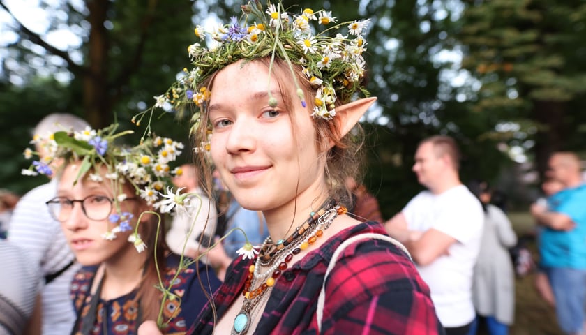 Młoda, uśmiechnięta dziewczyna w wianku na głowie podczas Leśnickiej Nocy Świętojańskiej w ramach Święta Wrocławia 2023