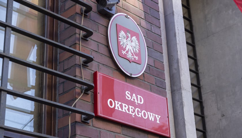 Godło polskie, pod spodem tablica czerwona z napisem "sąd okręgowy"
