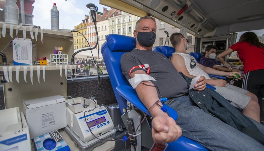 Mężczyzna oddający krew w punkcie terenowym