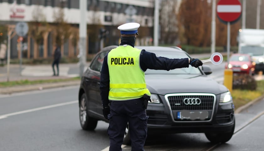 Na zdjęciu policjant na blokadzie drogi. Zdjęcie ilustracyjne. 
