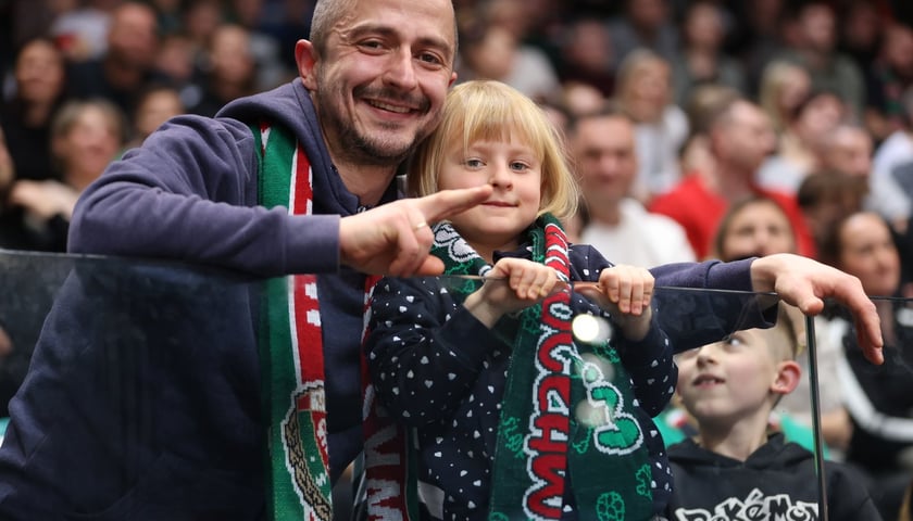 Mężczyzna i chłopiec, w tle kobiety, mężczyźni, dzieci w Hali Orbita na meczu WKS Śląsk Wrocław - Dziki Warszawa