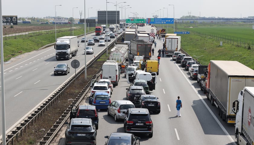 Korek na AOW, samochody i ludzie stojący na jezdni