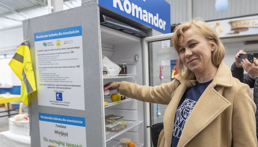 Kobieta przy lodówce na bazarze. Lodówka społeczna na targowisku Komandor przy ul. Komandorskiej.