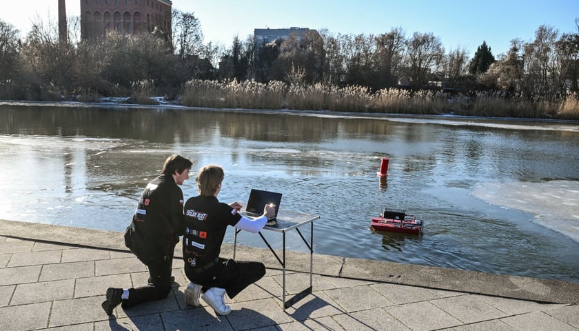 <p>Dw&oacute;ch student&oacute;w sterujących eksperymentalnym dronem wodnym F.O.K.A.</p>