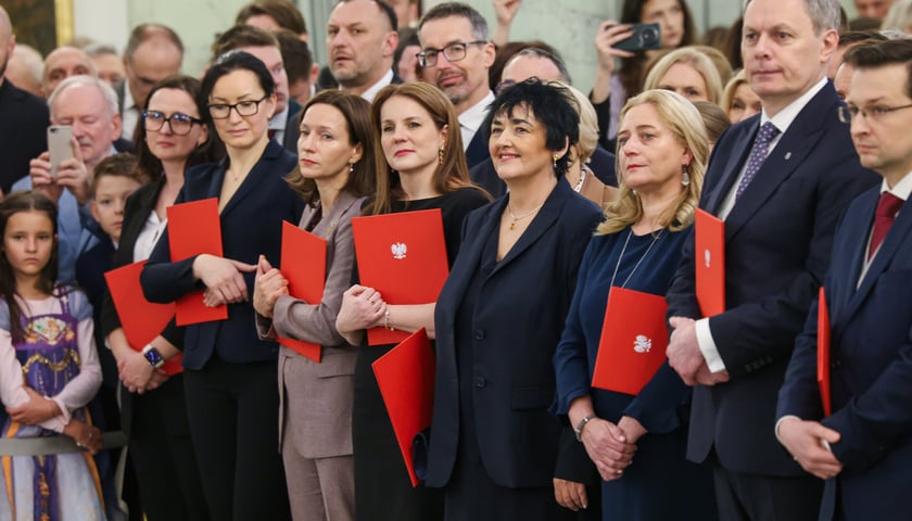 Uroczystość wręczenia nominacji profesorskich w Pałacu Prezydenckim. Na zdjęciu grupa osób w eleganckich ubraniach