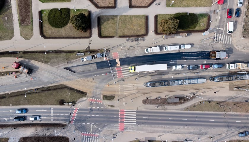 Układanie masy bitumicznej na ulicy Powstańców Śląskich między Orlą a Krzycką