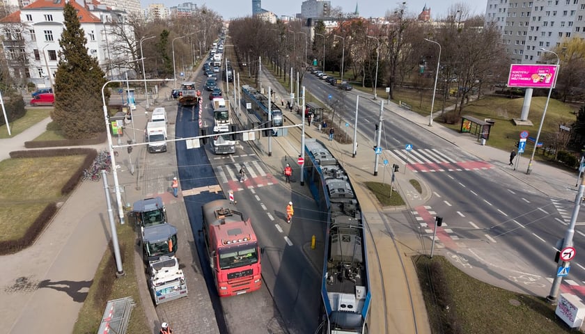 Układanie masy bitumicznej na ulicy Powstańców Śląskich między Orlą a Krzycką