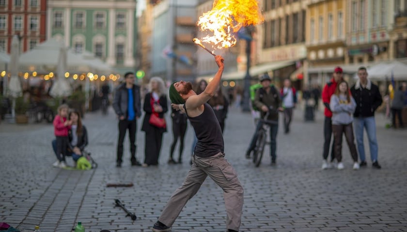 majowy wieczór we Wrocławiu, na zdjęciu połykacz ognia na Rynku