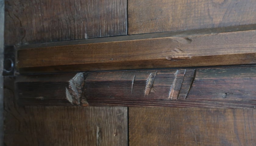 Powiększ obraz: Ślady, które pozostawiły topory buntowników na starych belkach drzwi