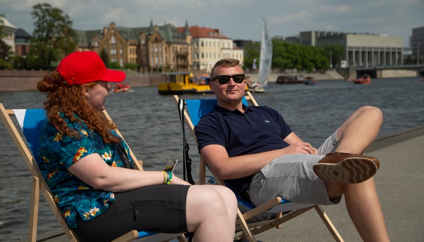 Powiększ obraz: Mężczyzna i kobieta wypoczywają na leżakach nad Odrą, Dzień Odry 2022