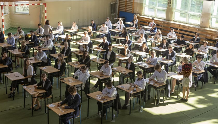Powiększ obraz: <p>Matura 2023 w VII LO. Egzaminy maturalne często odbywają się w salach gimnastycznych. Uczniowie siedzą pojedynczo przy stolikach.</p>