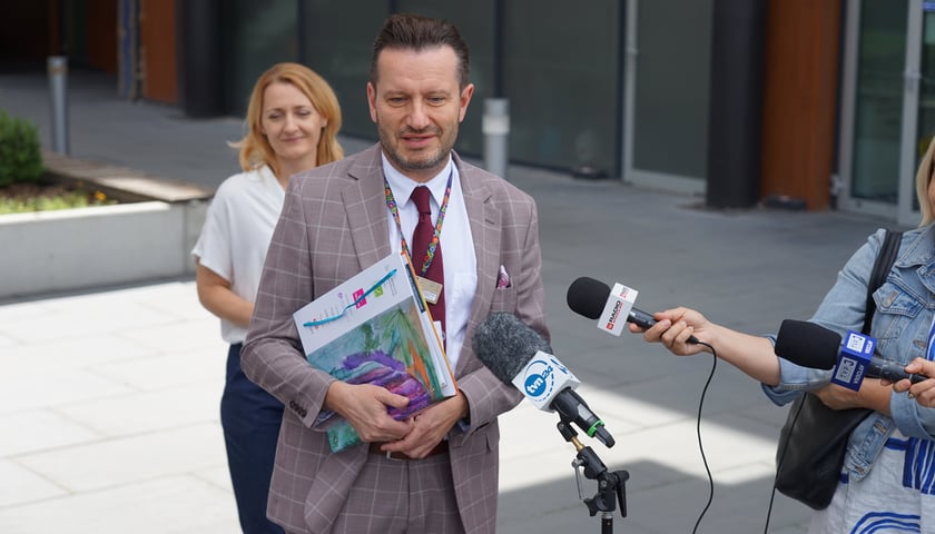 Powiększ obraz: <p>Konferencja z okazji rozpoczęcia wsp&oacute;łpracy między Uniwersyteckim Szpitalem Klinicznym we Wrocławiu a portalem onkorodzice.pl i Fundacją Iskierka (25.06.2024) - przy mikrofonie Krzysztof Kałwak</p>
