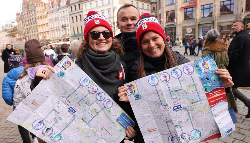 Powiększ obraz: Dwie kobiety i mężczyzna z mapami WrocWalk 2023