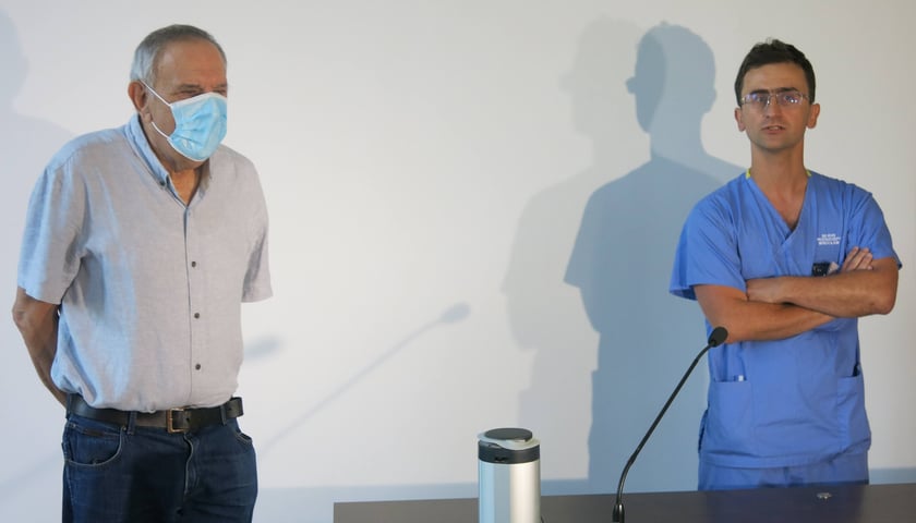 Powiększ obraz: Dwóch mężczyzn - pacjent w maseczce i lekarz w niebieskim ubraniu. Jan Kowalski - pacjent leczony na chłoniaka terapią CAR-T z dr Maciejem Majcherkiem z Kliniki Hematologii UMW.