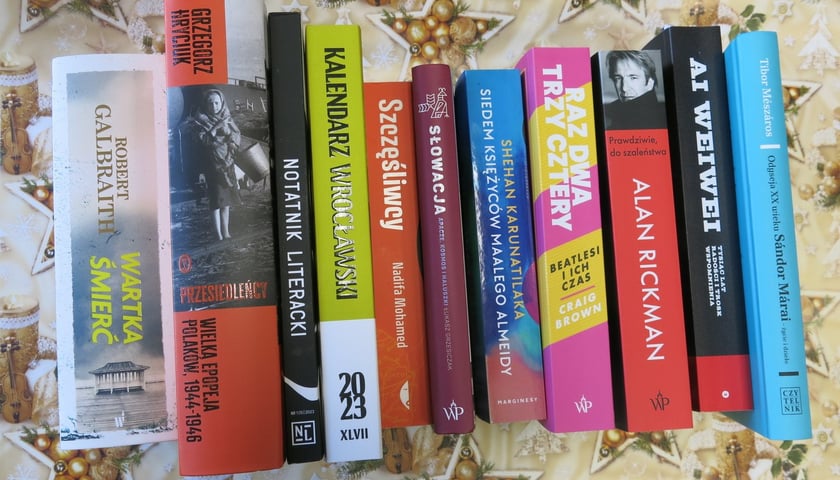 Na zdjęciu grzbiety książek, które są polecane jako prezenty pod choinkę