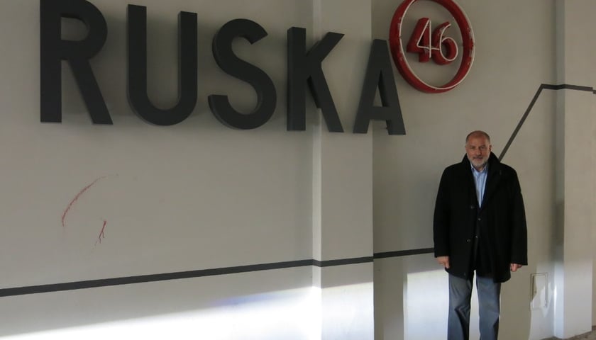 Prezydent Rafał Dutkiewicz na tle nowego neonu w przejściu do Pasażu Ruska 46 abc