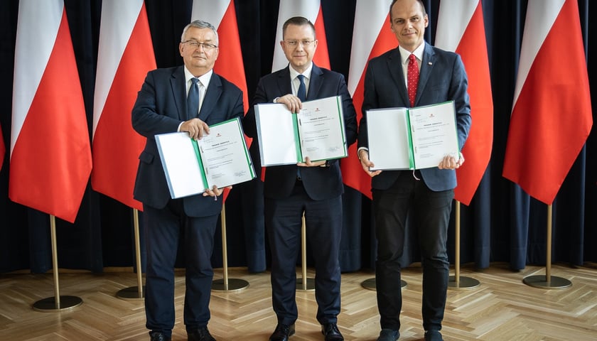 Powiększ obraz: Od lewej: Minister infrastruktury Andrzej Adamczyk, wiceminister infrastruktury Rafał Weber oraz szef gabinetu premiera, poseł Zagłębia Miedziowego Krzysztof Kubów z zatwierdzonym programem inwestycji dla prac przygotowawczych do przebudowy dróg krajowych nr 94 i 36 na odcinku Wrocław ? Lubin w województwie dolnośląskim