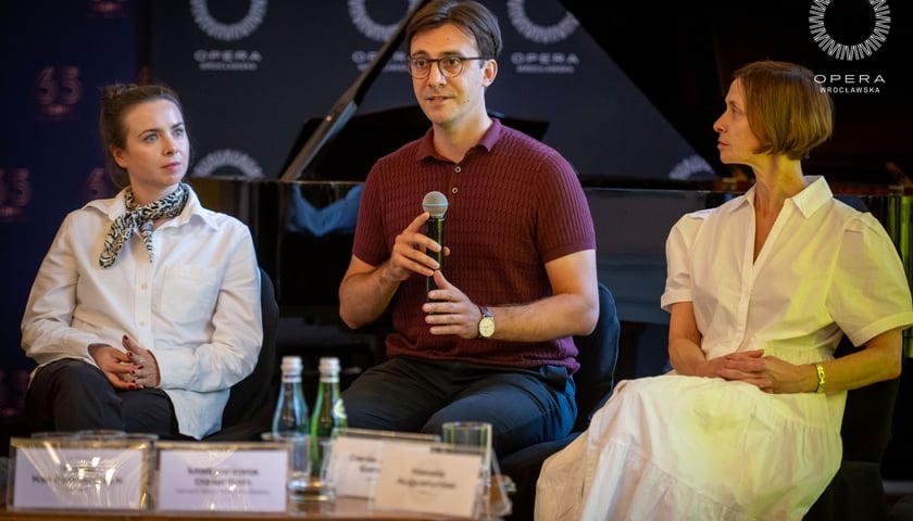 <p>Z mikrofonem Rafał Karczmarczyk, dyrygent i kierownik muzyczny projektu&nbsp;&nbsp;</p>