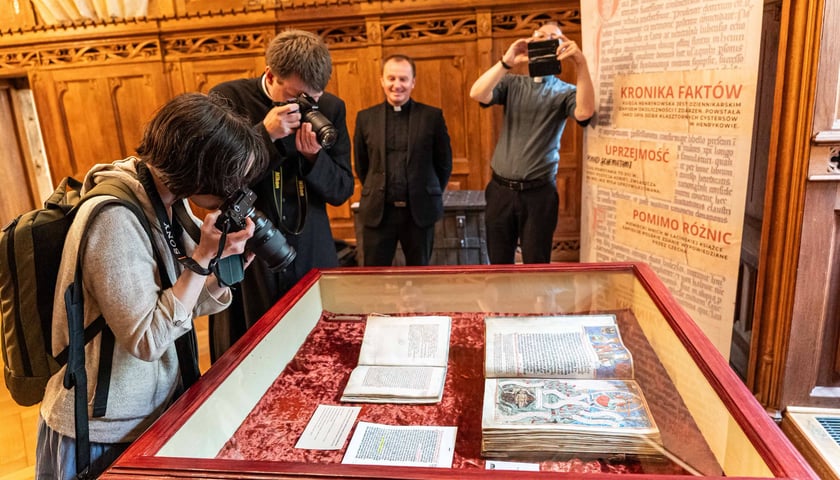 Na zdjęciu ludzie oglądający Księgę henrykowską w Muzeum Archidiecezjalnym we Wrocławiu