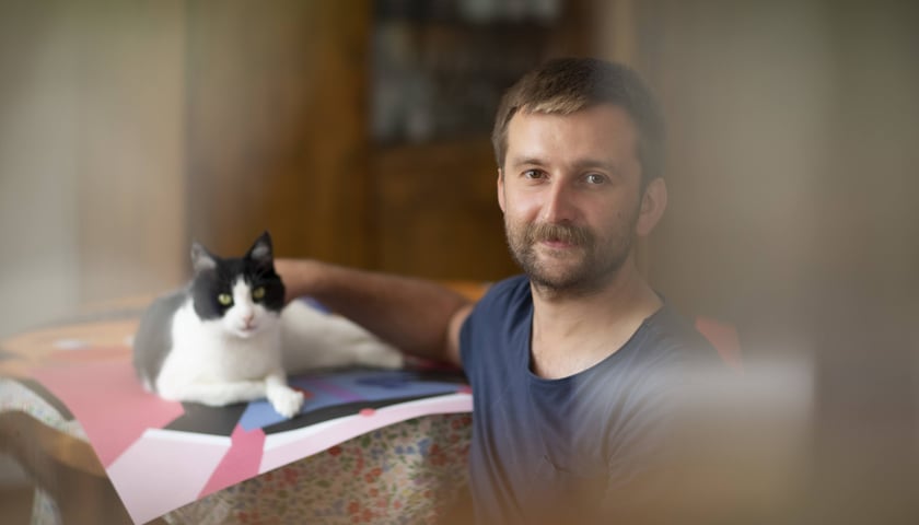 Jakub Zasada i jego domowe zwierzaki, które pozują do prac
