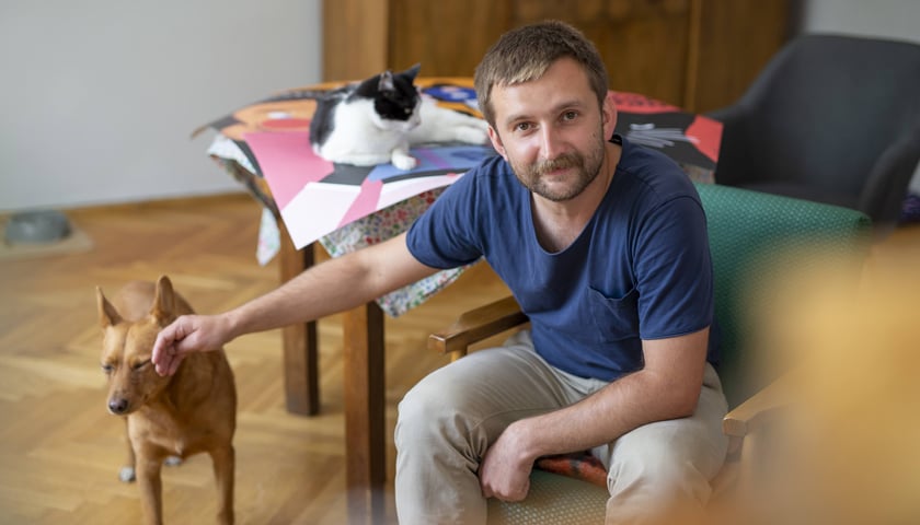 Jakub Zasada i jego domowe zwierzaki, które pozują do prac