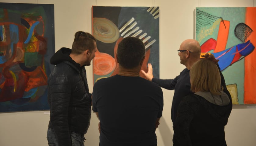 Na zdjęciu: cztery osoby oglądają obrazy na wystawie "Ich wizja" w galerii Oko w Oławie