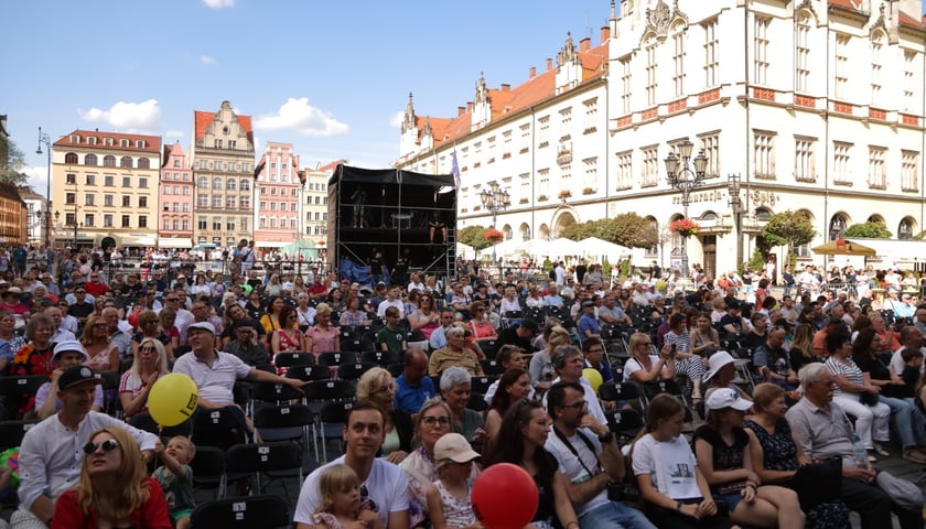 Powiększ obraz: Old Jazz Days 2023 w Rynku. Publiczność siedzi na krzesełkach na pl. Gołębim, w tle Ratusz