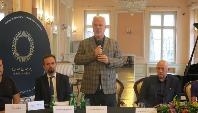 Michał Znaniecki, reżyser i dyrektor artystyczny Opery z mikrofonem, obok niego siedzą (po prawej dyrektor Opery Tomasz Janczak)