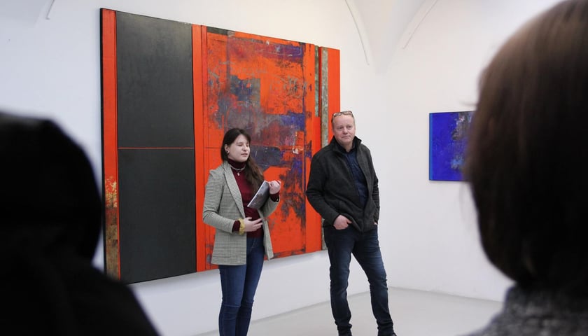 Kuratorka Katarzyna Zahorska i malarz Marian Kuczma przy czerwonym obrazie w Galerii Miejskiej we Wrocławiu