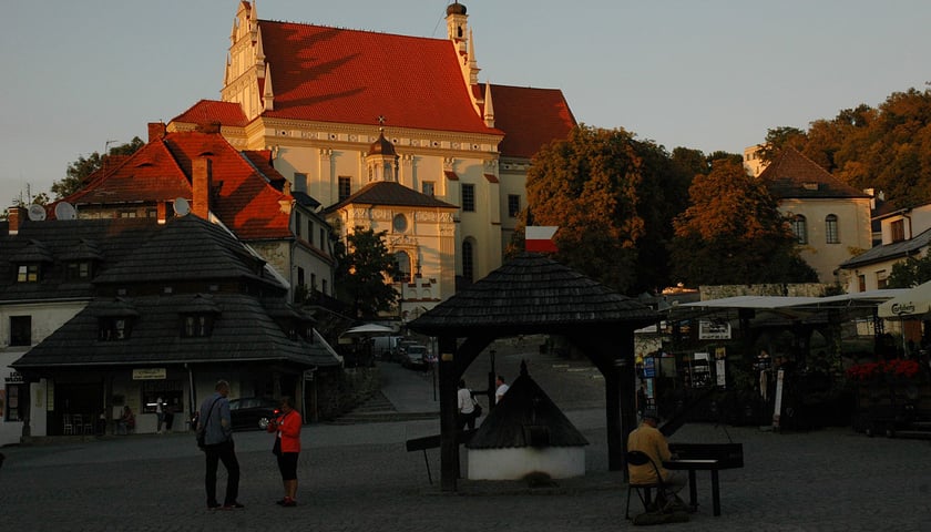 <p>Rynek w Kazimierzu Dolnym nad Wisłą z widokiem na kości&oacute;ł farny św. Jana Chrzciciela i św. Bartłomieja Apostoła</p>