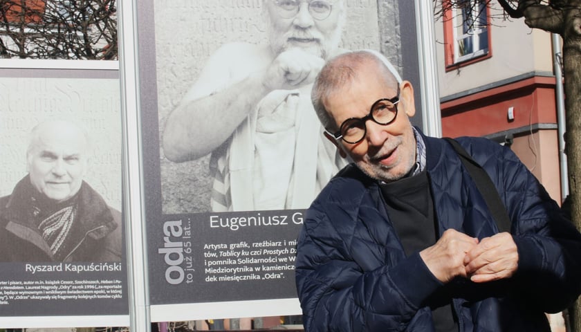 <p>Janusz Stankiewicz przy zdjęciu swojego brata Eugeniusza Geta-Stankiewicza</p>