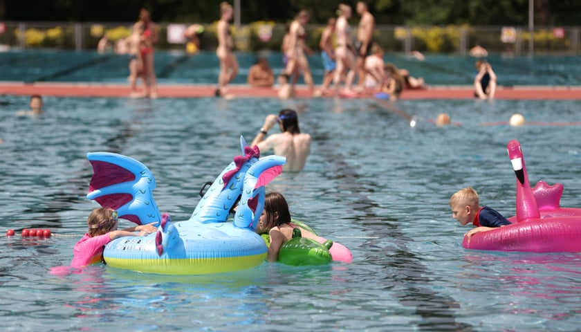 Powiększ obraz: Letnie kąpielisko Orbita przy Wejherowskiej. Dzieci w basenie z dmuchanymi, kolorowymi zabawkami