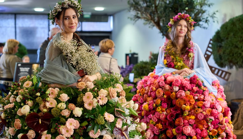Na zdjęciu dwie kobiety w kwietnych sukniach podczas World Flower Show we Wrocławiu