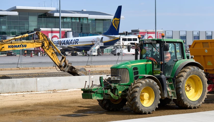 Rozbudowa wrocławskiego lotniska. Na pierwszym planie maszyny, w tle samolot i terminal 