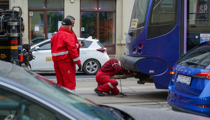 Dwóch pracowników sprawdza stan tramwaju