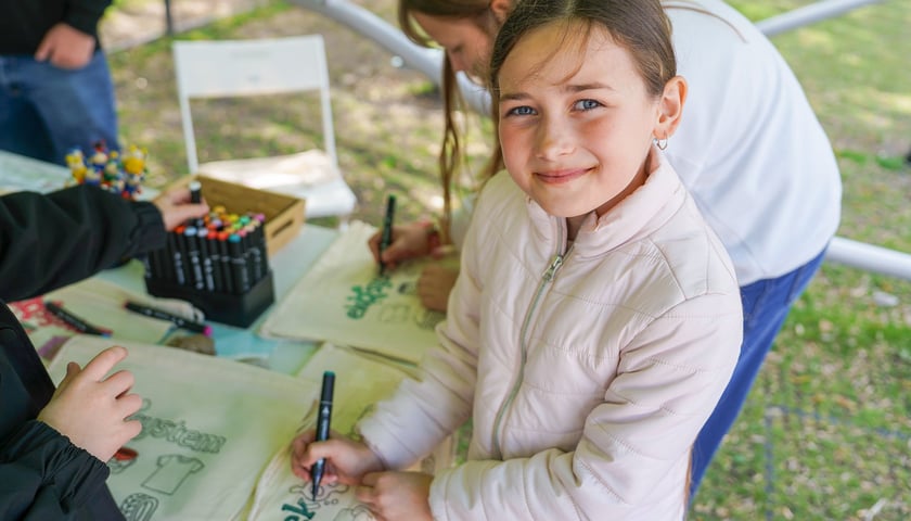 Festyn „Dbam to mam” na Starym Mieście - 21.04.2026 r. - dziewczynka pozuje z pomalowaną na festynie torbą