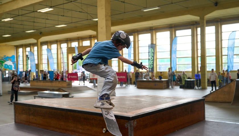 Jeden z chłopaków skacze na deskorolce w Centrum Sportów Ekstremalnych przy Legnickiej 65
