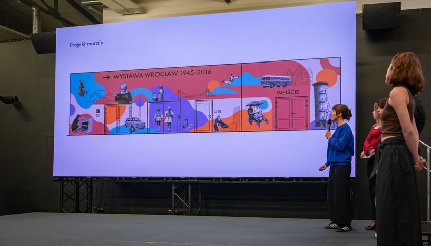 Prezentacja projektów w ramach programu WAZZA w Centrum Historii Zajezdnia. Na zdjęciu grupa młodych osób na scenie w tle ekran z prezentacją