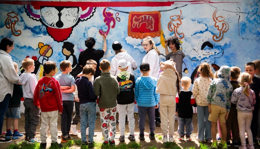 Studenci APS podczas malowania oraz towarzyszące im dzieci z ZSP nr 8 we Wrocławiu
