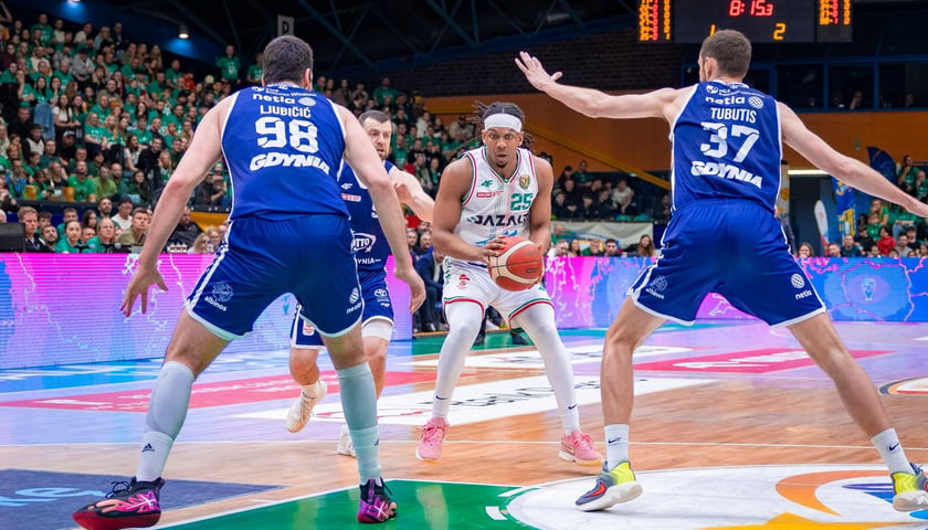 Zdjęcie ilustracyjne - koszykarz z piłką próbuje przejść przez blok zawodników przeciwnej drużyny - mecz play-off Śląsk Wrocław - Arka Gdynia w hali Orbita.
