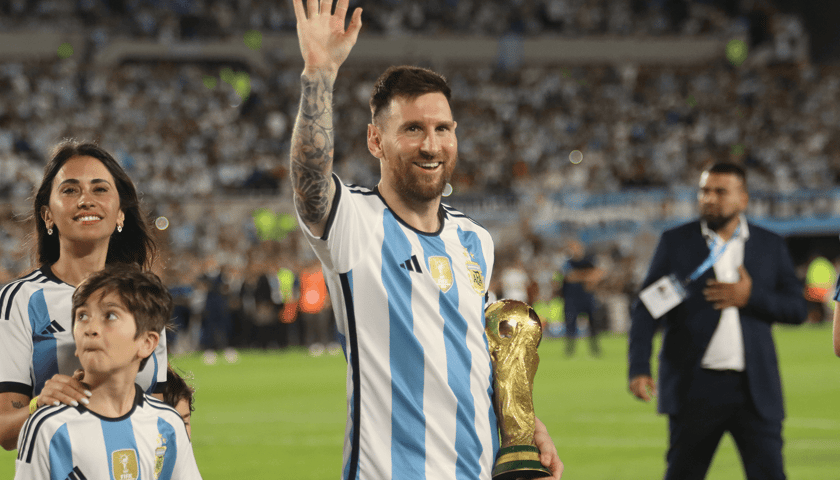 Leo Messi (w błękitno-białym stroju Argentyny) z Pucharem Świata w 2022 roku