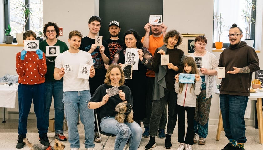 Mikrogranty, projekt "Portret Przedmieścia Oławskiego". Na zdjęciu grupa mieszkańców osiedla z pracami plastycznymi w rękach.