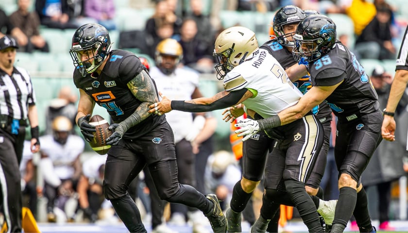 Zawodnicy Panthers Wrocław zatrzymują gracza Berlin Thunder próbującego odebrać piłkę rywalowi.
