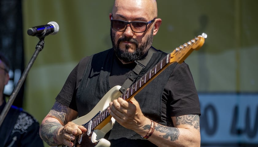 Grzegorz Skawiński, lider zespołu Kombii. Na zdjęciu mężczyzna gra na gitarze