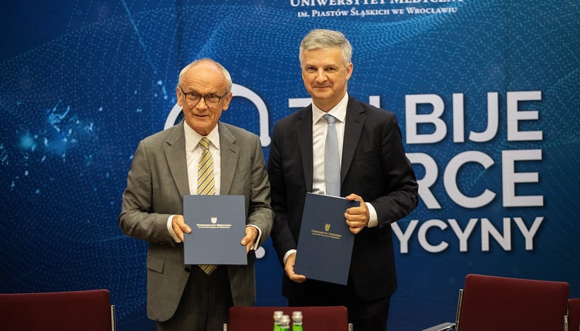 Prof. Piotr Ponikowski, rektor Uniwersytetu Medycznego we Wrocławiu, oraz Wiktor Janicki, prezes zarządu AstraZeneca Pharma Poland, po podpisaniu umowy o współpracy. Na zdjęciu dwóch mężczyzn w garniturach
