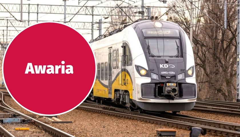Zdjęcie ilustracyjne - pociąg Kolei Dolnośląskich jadący po torach, w lewej części czerwone koło z białym napisem "Awaria" 