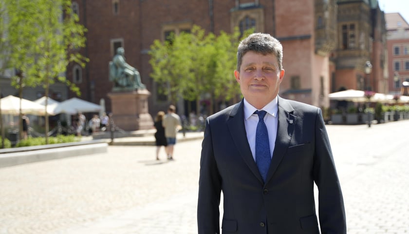 Ryszard Kessler w garniturze na tle Rynku