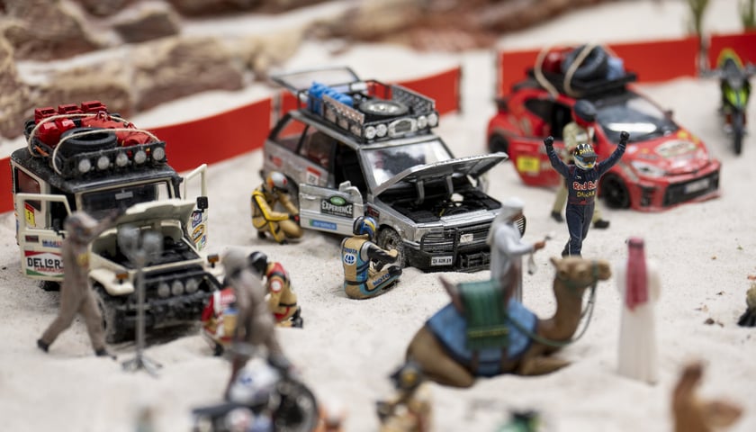 Makieta przedstawia świat w miniaturze. Na fotografii widoczne są samochody terenowe, kierowcy, wielbłądy na makiecie Miasto Dakar w Kolejkowie.